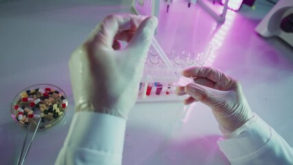 Wall Mural - laboratory technician adding fluid sample with pipette in test tube during scientific experiment in 