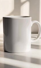 Fototapete - White ceramic mug mockup standing near window, casting soft shadows across minimalist kitchen table surface, providing clean neutral background for branding design presentations