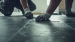 © Fidel - Flooring installer laying vinyl tiles on a floor. Featuring precision and care