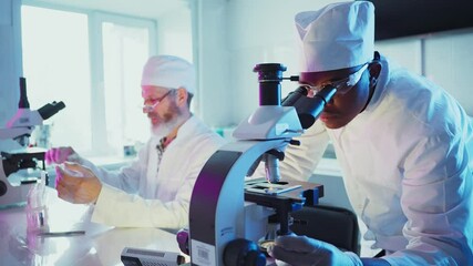 Wall Mural - professional medical researchers examining laboratory samples under microscope, wearing lab coats wh