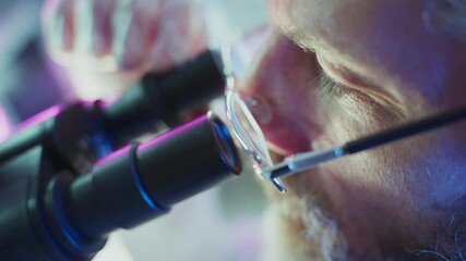 Wall Mural - concentrated scientist wearing glasses examining specimen through microscope, capturing precise scie
