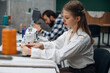 © standret - View from the side, sitting. People are working by the sewing machines indoors