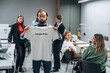 © standret - T-shirt with sample print text on it. People are working by the sewing machines indoors