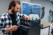 © standret - Installing plastic for 3d printer. Man is in the modern office, one person