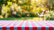 © Rhony - Empty tabletop with red and blue checkered tablecloth in a blurred summer picnic in garden background.