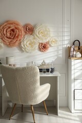 Poster - Beautiful decorative paper flowers on white wall and stylish furniture indoors