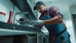 © keshia - Hispanic plumber repairing a pipe under a sink in a modern kitchen. Featuring problem-solving and technical skills