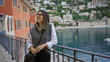 © Krakenimages.com - Woman smiling by the sea in villefranche france with colorful buildings and scenic landscape reflecting european charm and tranquility