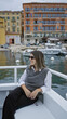 © Krakenimages.com - Woman smiling on boat in villefranche france with sea view, vibrant hotel backdrop, enjoying european vacation.