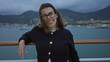 © Krakenimages.com - Woman smiling on cruise ship dock with mountains and ocean in the background, showcasing a young, hispanic woman enjoying an outdoor adventure.