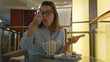 © Krakenimages.com - Woman enjoys dessert alone in luxury indoor bar, holding smartphone and wearing casual attire, reflecting relaxation and modern lifestyle.