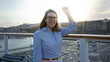 © Krakenimages.com - Woman smiling on cruise ship at sunset dock with city view wearing glasses and blue shirt outdoors enjoying travel experience.