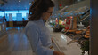 © Krakenimages.com - Young woman with glasses selecting food at a buffet in an indoor restaurant, surrounded by an array of colorful dishes, conveying a comfortable dining environment.