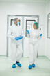 © Dejan - Two healthcare professionals engage in conversation while dressed in sterile attire, highlighting teamwork in a clinical environment.