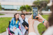 © Martí Rosselló - Caregiver taking photo of doctor and young woman in wheelchair - Close-up of smartphone capturing smiling doctor with young woman with cerebral palsy - Concept of cerebral palsy
