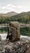 © OM - Backpack rests on a rock by a tranquil lake surrounded by lush forests and distant mountains at sunset