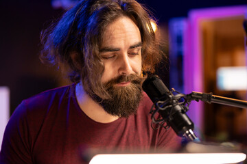 Leinwandbilder - Talented musician producer singing a new song on microphone in home studio, composing music an creating tunes with piano keyboard and daw software. Artist works with electronic equipment.