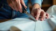 © Татьяна Антоненко - Close-up of hands cutting fabric with scissors in sewing workshop.