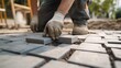 © Mcgui - Landscape paver installing decorative stone tiles in a garden walkway. Featuring design and durability
