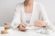 © Pixel-Shot - Young woman with cotton pad and different cosmetic products at table