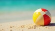 © Pornchai - Deflated beach ball half-buried in warm sand close to turquoise water , vacation, sunlight, ocean day