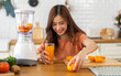 © Art_Photo - Portrait of beauty healthy asian woman making orange fruit smoothie with blender.girl preparing cooking detox cleanse with fresh orange juice in kitchen at home.health, vitamin c, diet, healthy drink