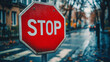 © Yoonnam - A modern, clean red stop sign with bold 'STOP' lettering stands on a city street, symbolizing traffic safety, awareness, control, and the importance of pausing in fast-paced urban life.