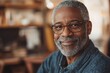 © EUT - Smiling mature Black man with gray beard and glasses indoors. Use it to represent wisdom, experience, and friendly professionalism.