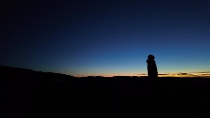 Wall Mural - silhouette of a man and countryside under the blue hour after sunset - before sunrise.