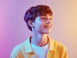 © Joesunt - Radiant Youth: A young man smiles brightly, illuminated by vibrant, colorful lighting, his genuine joy and hopeful expression filling the frame with positive energy.