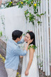 © Timeimage - Couple enjoying a tender moment by a white picket fence adorned with yellow flowers during a peaceful afternoon