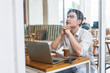 © Timeimage - Thoughtful young man reflects while working at a cafe with laptop, coffee, and smartphone during a quiet afternoon