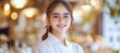 © Ilja - Portrait of a Young Asian Woman with Glasses Smiling in a Blurred Restaurant Background