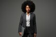 © alisaaa - Young African American woman with afro hairstyle wearing smart formal wear standing isolated on grey , carrying laptop