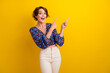 © deagreez - Photo of young amazed girl brown bob hair wearing blouse pointing fingers empty space right side isolated on yellow color background