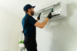 © AntonioDiaz - Technician cleaning air conditioner filter during maintenance service
