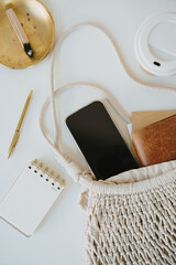 Wall Mural - Flat Lay of Smartphone with Notebook and Golden Tray in Natural Light