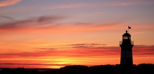 Wall Mural - crisp point lighthouse silhouetted against a vibrant sunset sky, scenic, rocks, photography