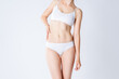 © staras - Slim woman in white underwear on gray background, body care concept