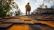 © Moonsterkat - A roofer stands on a new roof, overseeing construction materials.
