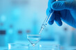 © NisatFarjana - test tube with blue liquid Science Lab Technician Wearing Gloves and Goggles Handling Test Tube During Important Breakthrough Experiment in Biomedical and Chemical Research Study