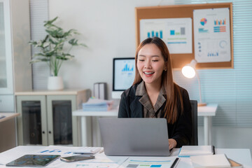 Poster - Asian businesswoman working with laptop and smiling in modern office