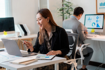 Poster - Asian businesswoman having video call and pointing at laptop screen during online meeting in office