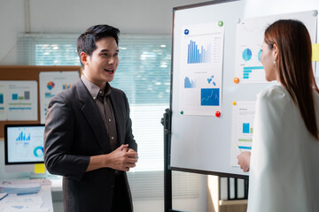 Poster - Asian businesspeople discussing company strategy using charts and graphs on whiteboard