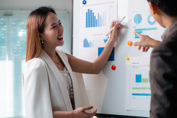 Poster - Asian businesspeople analyzing financial charts on whiteboard during a meeting