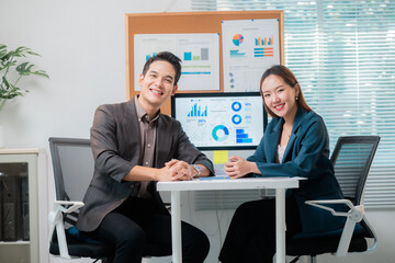 Poster - Asian business partners smiling and working together analyzing charts in the office