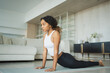 © Юлия Завалишина - Yoga fitness workout training. Healthy African girl practicing yoga at home. Woman training Pilates doing sports exercise on yoga mat indoor. Girl have training workout for weight loss. Sport fitness