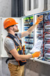 © puhimec - Male electrician working in electrical panel. Male electrician in overalls.