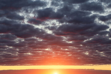 Wall Mural - Epic dramatic sunset, sunrise on storm sky with dark fluffy cumulus clouds, orange yellow sun and sunlight abstract background texture