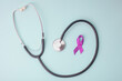 © Queenmoonlite Studio - Stethoscope And Purple Awareness Ribbon On Light Blue Background. Cancer Awareness Month.